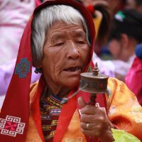 Old women attending festival with prayer wheels Windhorse Tours